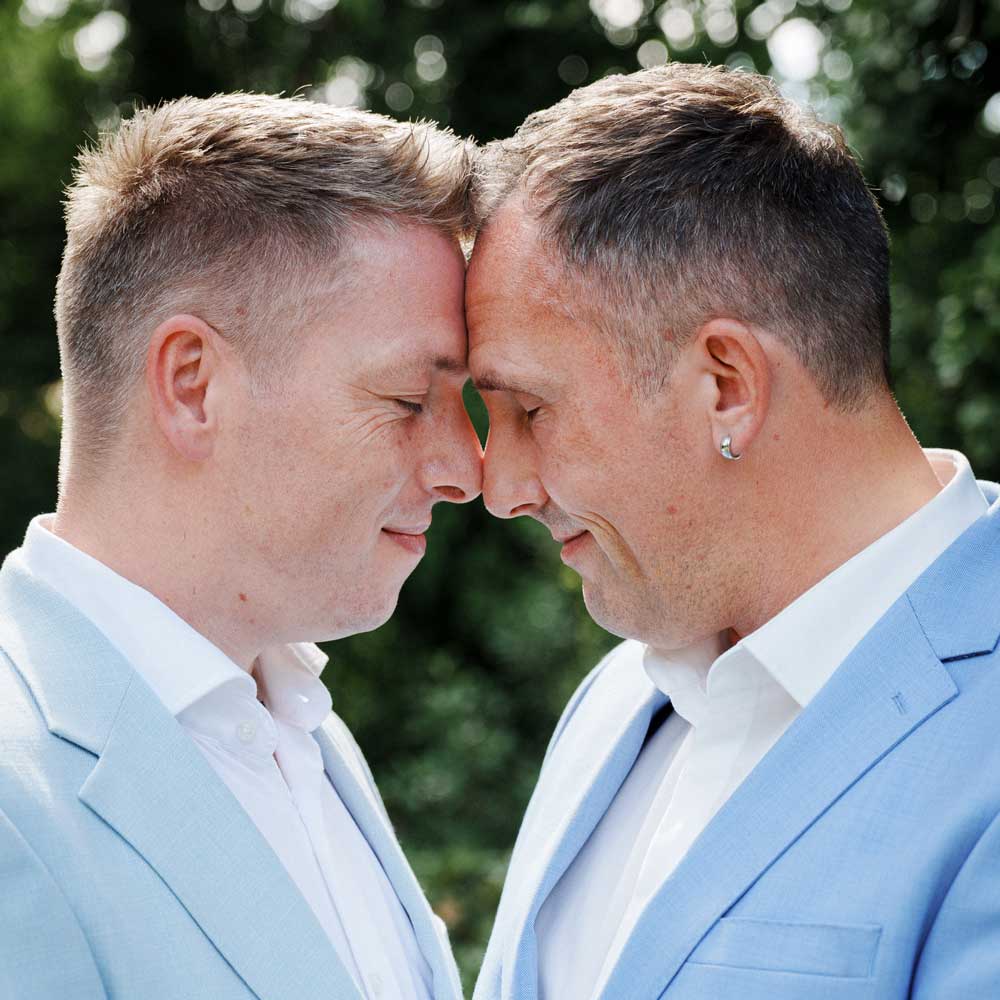 Zwei Männer sind zärtlich Stirn an Stirn gelehnt