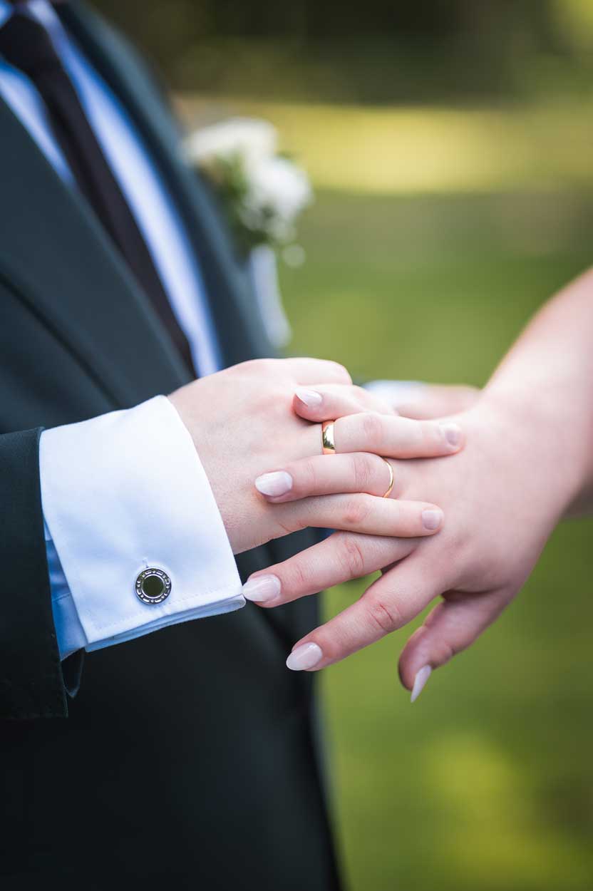 Ein Close-Up Foto von den Eheringen an den Ringfingern