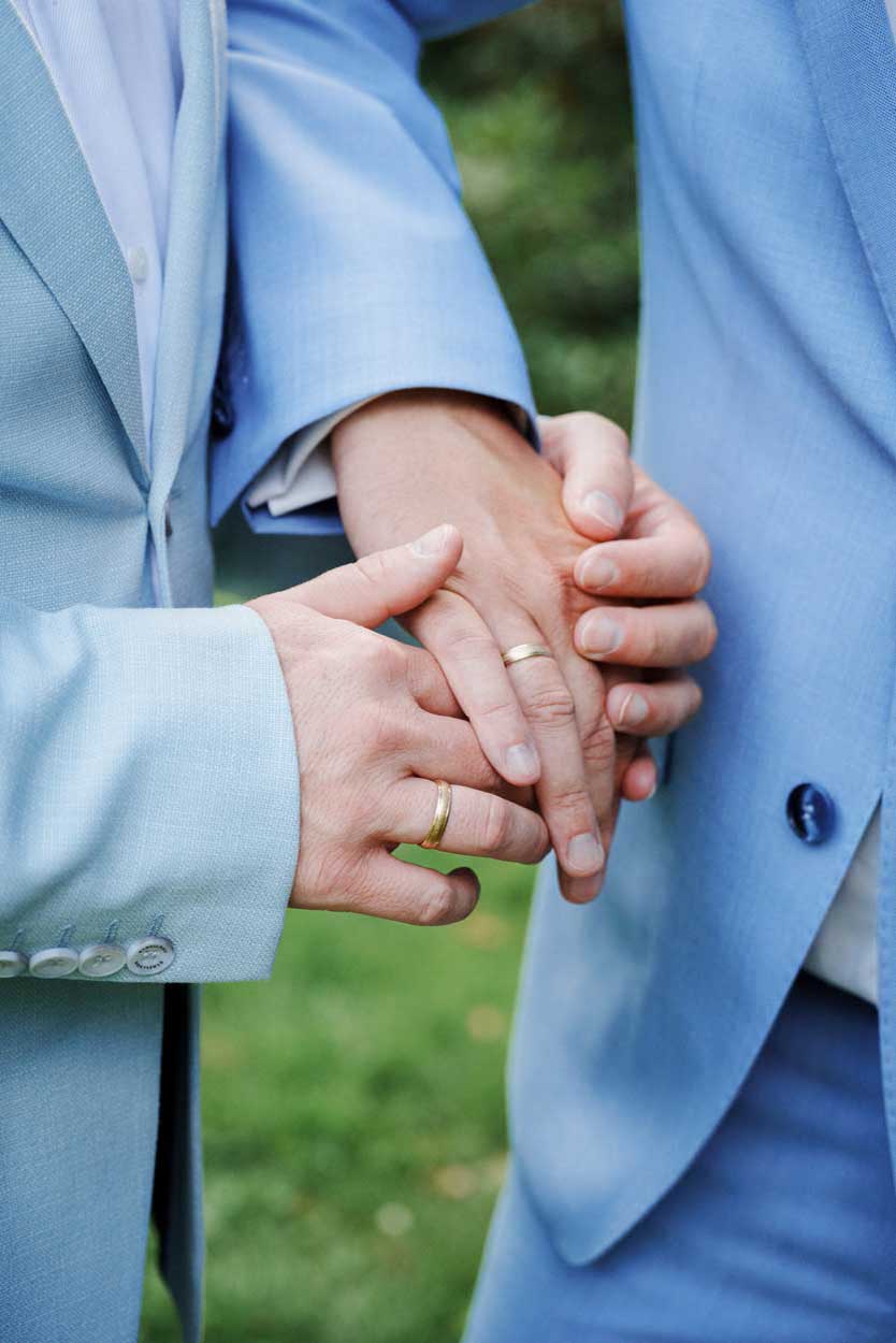 Fotoshooting zwei Männer legen ihre Hand aufeinander, man sieht die Ringe