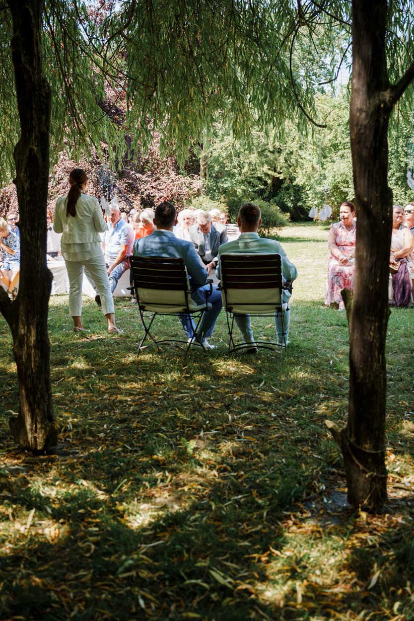 Das Brautpaar sitzt neben der Traurednerin