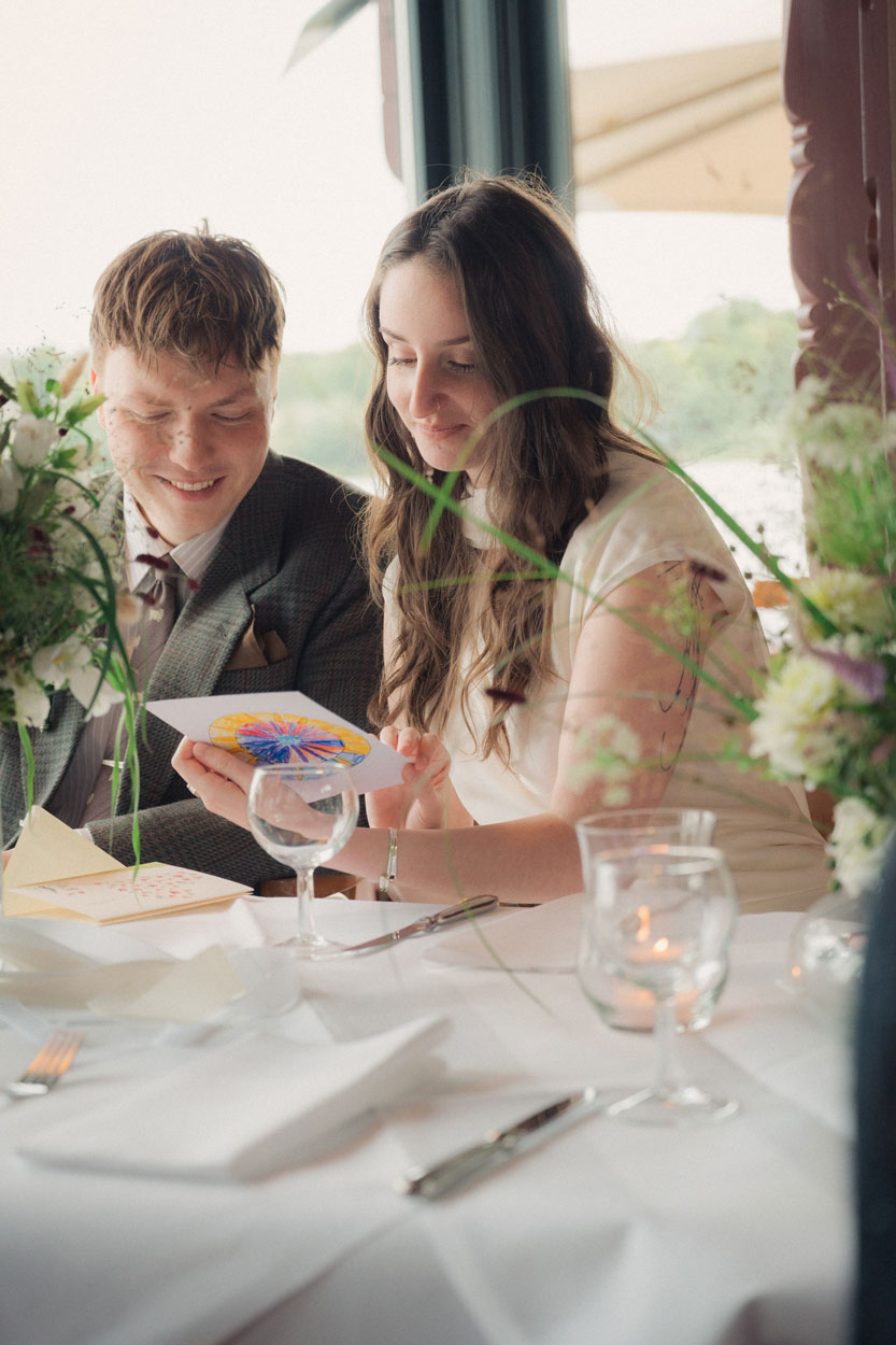 Braut und Bräutigam schauen sich die Einladungskarte an
